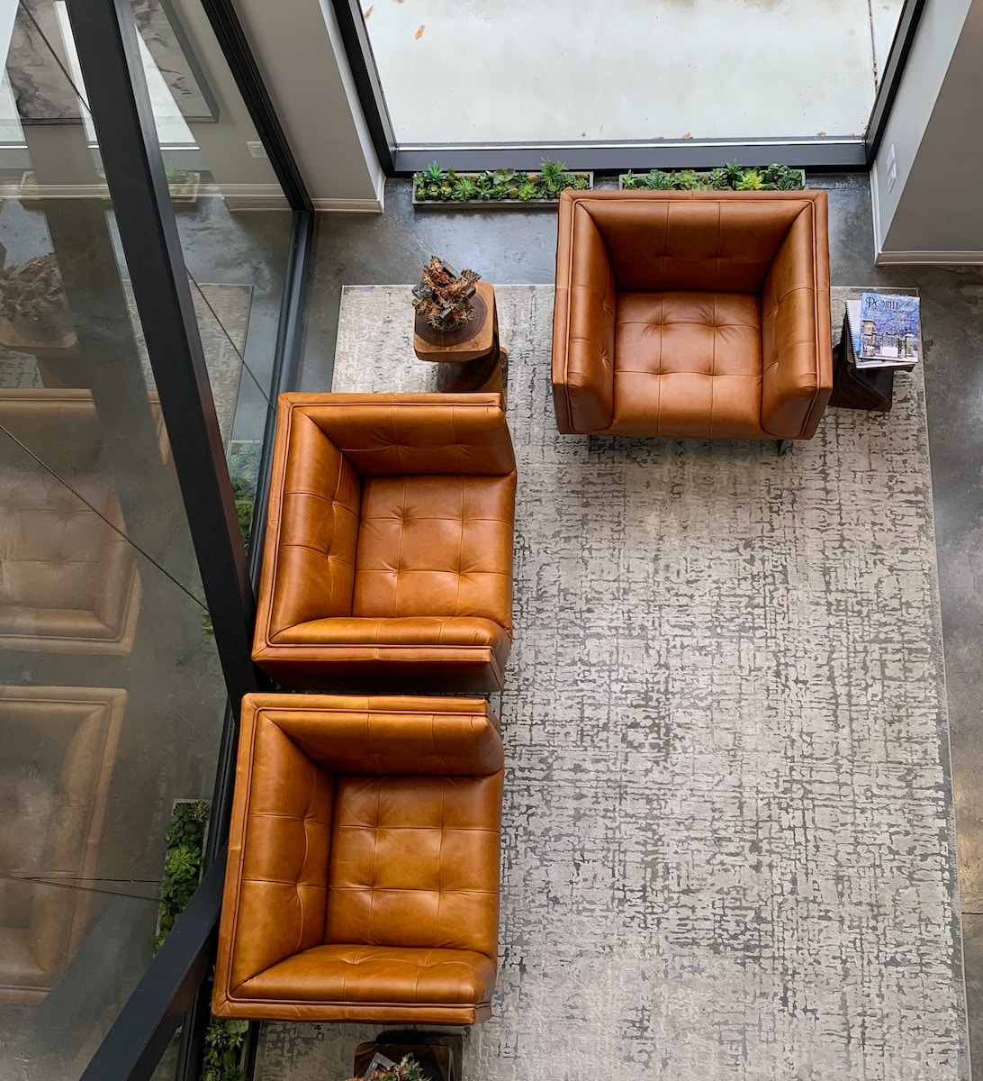 brown leather couch on gray floor